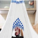 نمایش یک حجاب سنتی به رنگ آبی و سفید با نقوش هندسی متقارن، آویزان بر روی مانکن در فضای داخلی کلاس درس مدرسه
