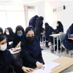 دانش‌آموزان دختر در محیط کلاس درس نشسته‌اند و در فعالیتی تحصیلی شرکت می‌کنند