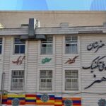 نمای بیرونی ساختمان مدرسه پلی‌تکنیک هنر با سردر ورودی و تابلوی فارسی بر روی دیوار