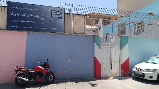نمای ورودی هنرستان پویندگان کسب و کار در میدان امامت تهران‌نو با تابلوی مدرسه و درب حیاط