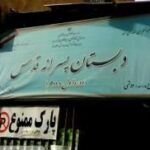 سردر دبستان دولتی با تابلوی آبی نام‌نویس و تابلوی پارک سرویس زیر آن