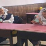 دو دانش‌آموز دختر در حال انجام یک فعالیت علمی/عملی در کلاس درس