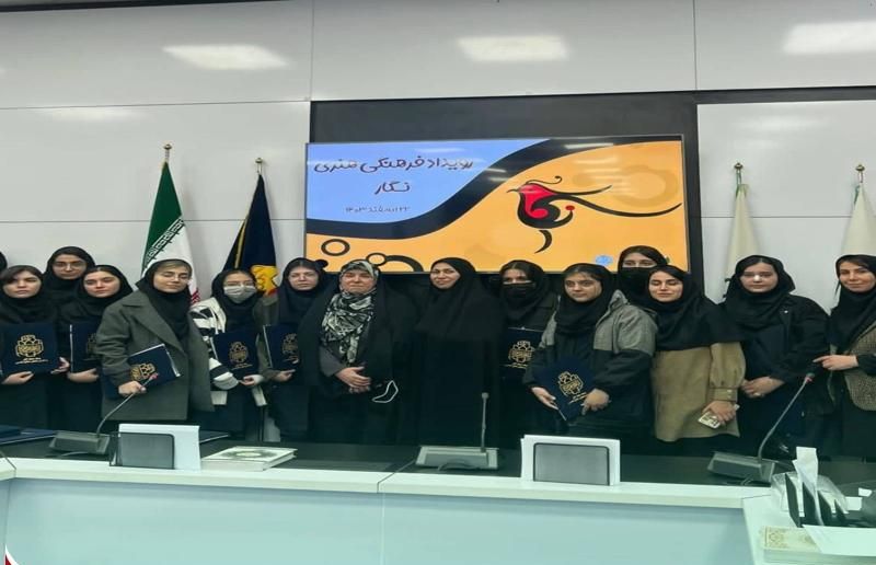 دختران دانشآموز در مراسم تقدیری با حضور پرچمهای ایران و بنر تجلیل