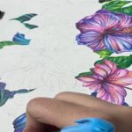 دانش‌آموز در حال نقاشی و طراحی گل‌های رنگین با قلم‌های رنگی در کلاس درس