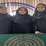 سه دانش‌آموز دختر در حال نمایش یک اثر هنری دستساز با طراحی ماندالا و تزئینات طلایی