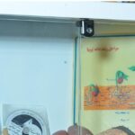 جدار کلاس درس با ملصقات و نمودارهای آموزشی شامل مخطط نشأة گیاه و کتاب درسی علوم