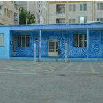 حیاط مدرسه با دیوار آبی رنگ شده و نقاشی‌های رنگارنگ طرح مارپیچ