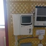 تجهیزات کامپیوتری قدیمی و دستگاه‌های الکترونیکی نصب‌شده روی دیوار مدرسه