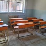 اتاق کلاس مجهز به میزهای چوبی و صندلی‌های دانش‌آموز با نورگیری طبیعی از پنجره