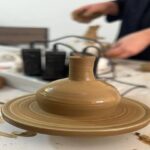 دانش‌آموزان در حال فعالیت سفال‌گری و کار بر روی دیسک سفال‌گری در کلاس هنرهای دستی