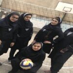 دختران دانش‌آموز در حیاط مدرسه درحال بازی والیبال