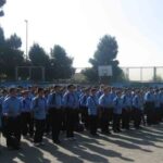 تجمع دانش‌آموزان در حیاط مدرسه با لباس یکسان آبی در یک ردیف برای شرکت در مراسم صبحانه روز
