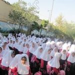 دانش‌آموزان مدرسه با پوشش مقررات در حیاط مدرسه جمع‌شده برای مراسمی یا تجمعی درون‌مدرسه‌ای