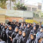 گروهی از دانش‌آموزان دختر در حیاط مدرسه برای عکس جمعی جمع شده‌اند