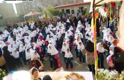 دانش‌آموزان مدرسه در حیاط برای یک مراسم یا جلسه اجتماعی گرد هم آمده‌اند