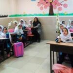 دانش‌آموزانی در کلاس درس در حال فعالیت یادگیری گروهی با دیکوراسیون‌های صورتی و گل‌های تزیینی