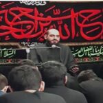 مراسم مذهبی دانش‌آموزان با سخنران پشت میکروفن و بنرهای قرآنی در پس‌زمینه