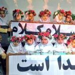 دانش‌آموزان در حال حضور در یک مراسم مدرسه‌ای با تزیینات گلی و بنر فارسی