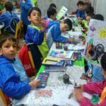 دانش‌آموزان در حال انجام فعالیت نقاشی و رنگ‌آمیزی در کلاس درس با آبرنگ و مواد هنری
