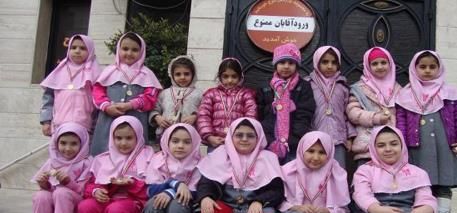 گروهی از دانش‌آموزان دختر با لباس صورتی در حیاط مدرسه برای یک رویداد یا مراسم