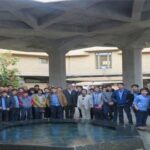 دسته‌ای از دانش‌آموزان زیر سقف بتنی و ستون‌های ساختمان برای مراسم یا رویداد مدرسه