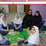 دانش‌آموزان در حال انجام یک فعالیت گروهی عملی برای تهیه و خوردن غذا در محیط داخلی مدرسه