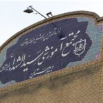 سردر دائمی ساختمان با تابلوی آبی‌رنگ و کاشی‌کاری اسلامی به‌طور سنتی تزیین‌شده که نام مدرسه را نمایش می‌دهد