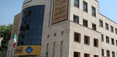 نمای بیرونی ساختمان مدرسه شهید مطهری با درب ورودی و تابلوی معرف
