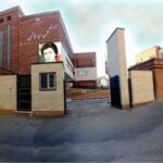 نمای بیرونی ساختمان دبیرستان شهید سید فاطمی در نازی‌آباد تهران با درب و دیوار آجری