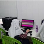 دانش‌آموزان با حجاب در حال کار روی رایانه‌های جانبی در اتاق کامپیوتری مدرسه