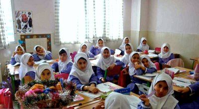 دانش‌آموزان دختری با روسری نشسته در کلاس درس که در حال فعالیت‌های یادگیری هستند