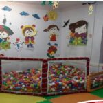 کلاس درس کودکان با حوض توپ رنگی و تزئینات دیواری فصلی و شخصیت‌های خلاق