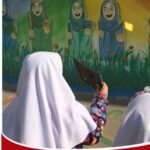 دانش‌آموزانی در حال استفاده از دستگاه الکترونیکی در حیاط مدرسه در کنار دیوار رنگی