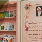 کتابخانه مدرسه با شلف‌های کتاب‌های رنگین و متن‌های انگیزشی فارسی روی دیوار