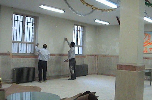 دید داخلی نمازخانه مدرسه با دیوارهای سفید، پنجره‌های ایمن، و فضایی آرام و خالی