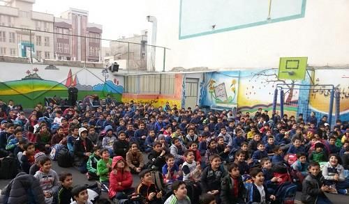 تجمع دانش‌آموزان در حیاط مدرسه برای شرکت در یک مراسم یا رویداد جمعی