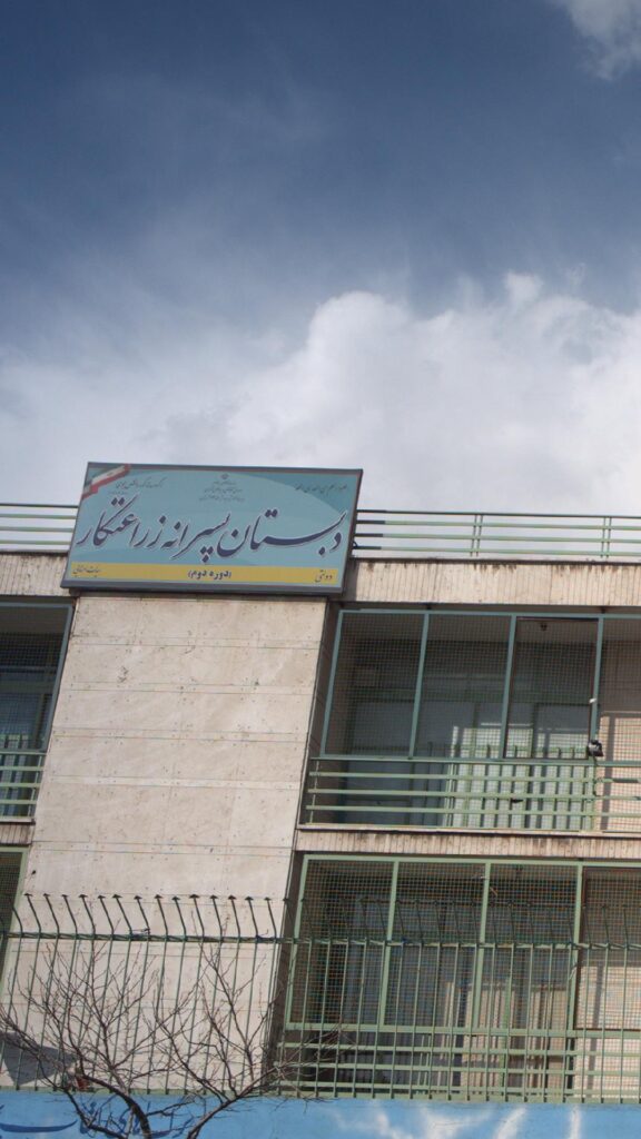 نمای بیرونی ساختمان دبستان پسرانه زراعتکار همراه با تابلوی مدرسه
