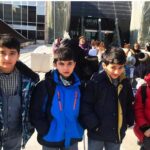 دستهای از دانشآموزان پوشیده به لباس نو و رسمی در حیاط مدرسه برای یک رویداد یا مناسبت گروهی
