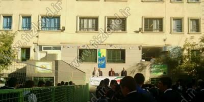 نمایی از حیاط مدرسه با دیدِ ساختمان اصلی و دانش‌آموزانی نشسته