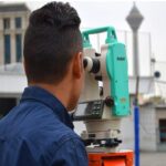 دانش‌آموز در حال استفاده از تئودولایت برای انجام فعالیت نقشه‌برداری و اندازه‌گیری فیلد در فضای باز مدرسه
