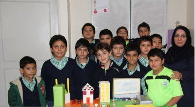 دانش‌آموزان در حال نمایش پروژه ساخت‌وساز معماری با مدل‌های کاغذی و مقوایی در کلاس درس