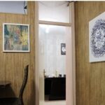 داخل یک کلاس درس با دیوارهای چوبی، مبلمان و آثار هنری دانش‌آموزان روی دیوار