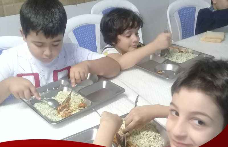 دانش‌آموزان در حال انجام فعالیت علمی عملی و کار با نمونه‌های آزمایشی در کنتینرهای متالیک پشت میز کلاسی