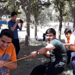 گروهی از دانش‌آموزان لباس نارنجی‌پوش در حیاط مدرسه در حال انجام فعالیت هماهنگی و تیم‌بندی