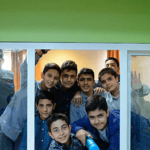 گروهی از دانش‌آموزان جوان در حال پوز دادن برای عکس دسته‌جمعی در محیط داخلی مدرسه