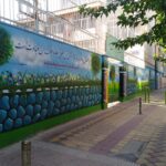 دیوار نقاشی‌شده و حلقه بسکتبال حیاط مدرسه نبوت در هفت‌حوض تهران
