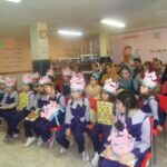 دانش‌آموزانی در حال برگزاری مراسمی در کلاس درس با حضور والدین و معلمان