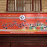 سردر و تابلوی فلزی قرمز رنگ مدرسه پیش‌دبستان و دبستان درشریفی