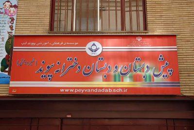 سردر و تابلوی فلزی قرمز رنگ مدرسه پیش‌دبستان و دبستان درشریفی