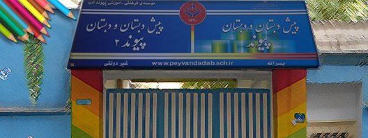 نمای ورودی ساختمان مدرسه با درب فلزی و تابلوی دائمی